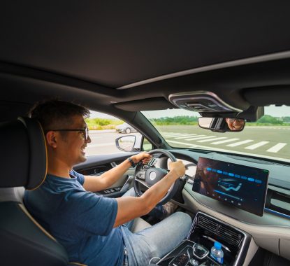An Asian man drives from town to go on a summer vacation. Happy Asian man in casual wear and beautiful new driving glasses.